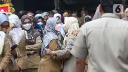 Pegawai Pemprov DKI mengantre saat halal bihalal di Balai Kota DKI, Jakarta, Senin (9/5/2022). Gubernur Anies Baswedan menggelar halal bihalal bersama para ASN Pemprov DKI Jakarta seusai libur Lebaran 2022. (Liputan6.com/Herman Zakharia)