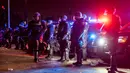 Petugas penegak hukum berjaga-jaga ketika mereka berhadapan dengan para demonstran saat aksi protes menyusul operasi imigrasi federal, di lingkungan Compton, Los Angeles, California pada tanggal 8 Juni 2025. (ETIENNE LAURENT/AFP)