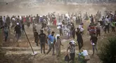 Orang-orang membawa pasokan bantuan dari Gaza Humanitarian Foundation (GHF), sebuah kelompok bantuan swasta yang didukung oleh Amerika Serikat, di Jalur Gaza Tengah pada 8 Juni 2025. (Eyad BABA/AFP)