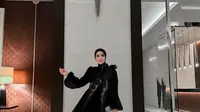 Sementara saat momen resepsi, Fairuz A Rafiq menunjukkan pesona elegan dalam balutan maxi dress dan hijab serba hitam. [@fairuzarafiq].