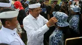 Gubernur Jawa Barat Dedi Mulyadi merapikan topi yang dikenakan salah satu siswa peserta program Pembinaan Karakter dan Bela Negara di lapangan Markas Divisi Infanteri 1 Kostrad, Cilodong, Kota Depok, Senin (9/6/2025). (Liputan6.com/Herman Zakharia)